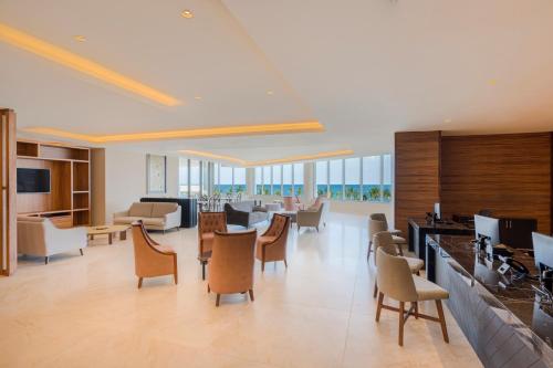 a large lobby with chairs and a waiting room at Royalton Splash Riviera Cancun, An Autograph Collection All-Inclusive Resort in Cancún