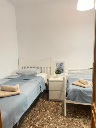 sypialnia z 2 łóżkami i szafką nocną w obiekcie UIM Mediterraneo M Cristina con garaje Wifi w mieście Puerto de Sagunto