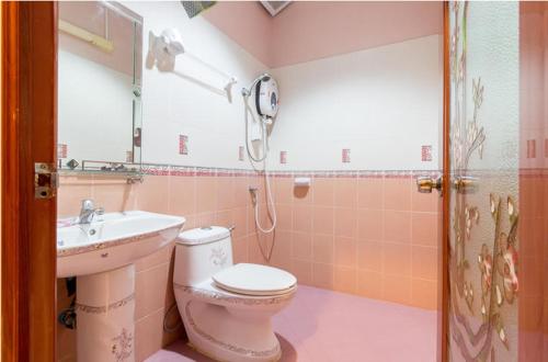 a pink bathroom with a toilet and a sink at Naengnoi resort kohlarn in Ko Larn