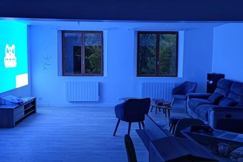 a blue room with a couch and a tv at La Biquette in Novy-Chevrières