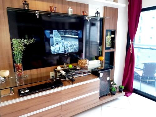 a large entertainment center with a large flat screen tv at Landscape Beira Mar Fortaleza in Fortaleza