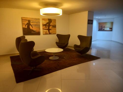 a lobby with chairs and a table and a painting at Landscape Beira Mar Fortaleza in Fortaleza