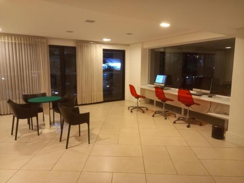 a room with a desk and chairs and a table at Landscape Beira Mar Fortaleza in Fortaleza