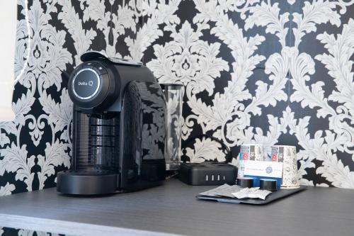 a coffee maker sitting on a table next to a wall at Hostal Boutique I Host You in Madrid