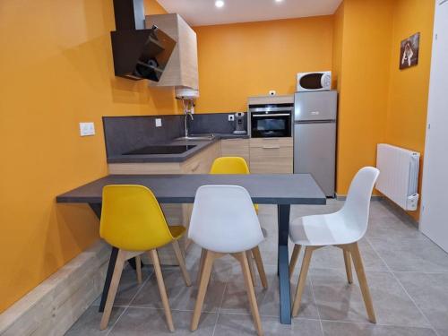 een keuken met een tafel en vier gele stoelen bij Bel Appart - Rez-de-chaussée - Hyper centre in Saint-Omer