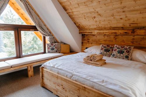 sypialnia z łóżkiem z ręcznikami w obiekcie Challet Tonka w Zuberzcu