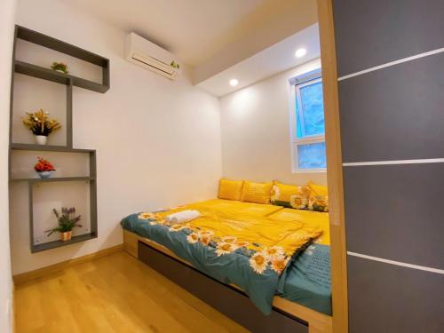 Dormitorio pequeño con cama con sábanas amarillas en Căn hộ MELODY Vũng Tàu - Mai Oanh Homestay en Vung Tau