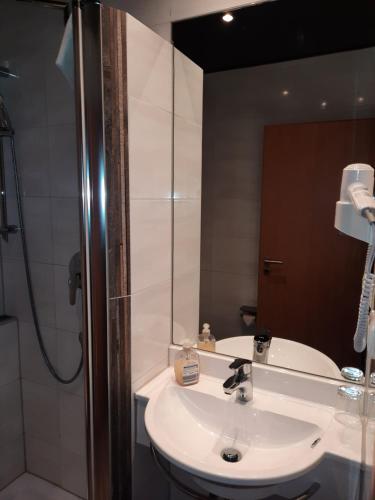 y baño con lavabo blanco y ducha. en Hotel-Gasthof Talblick, en Esselbach