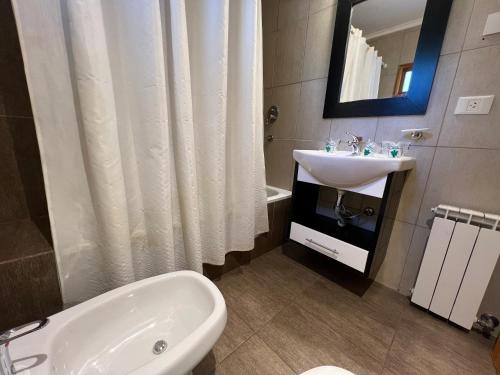 uma casa de banho com um lavatório, uma banheira e um WC. em Hostería y Cabañas Quime Quipan by Nordic em San Carlos de Bariloche