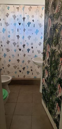 a bathroom with a shower curtain and a sink at Casa de Mar in Puerto Madryn