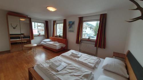 Cet appartement comprend une chambre avec deux lits et un salon. dans l'établissement Easy Home Johanna - Central Kirchberg, à Kirchberg in Tirol