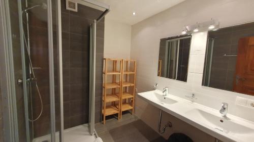 a bathroom with two sinks and a glass shower at Easy Home Johanna - Central Kirchberg in Kirchberg in Tirol