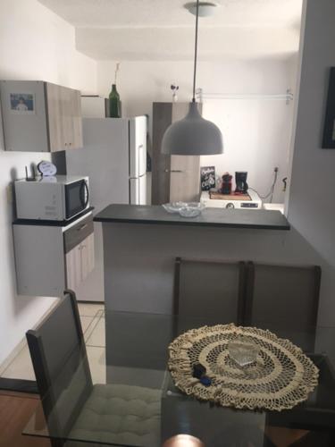 a kitchen with a counter and a table and a chair at APT A 10 MIN DA CIDADE DE PENEDO in Resende