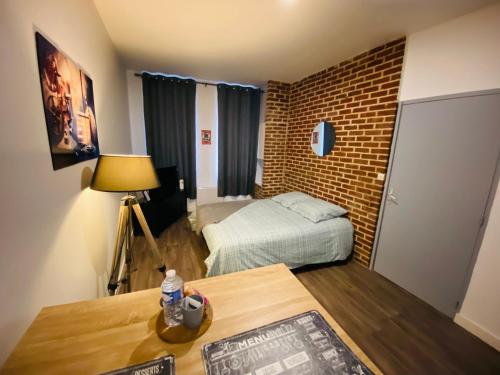 a small room with a bed and a table at Le Studio 11 Abbeville centre baie de Somme in Abbeville