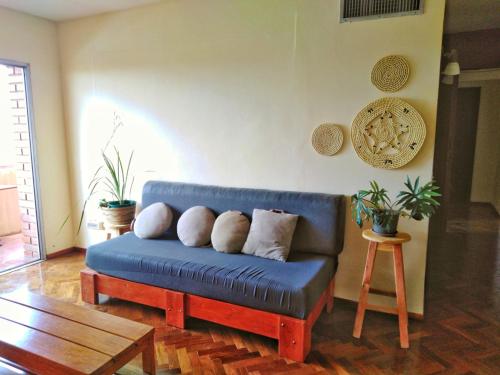 a blue couch in a living room with a table at Amplio depto de 2 dormitorios, Zona Plaza Uruguaya in Asunción