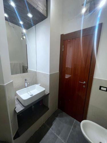 a bathroom with a sink and a wooden door at Holiday Studio Castel di Sangro in Castel di Sangro
