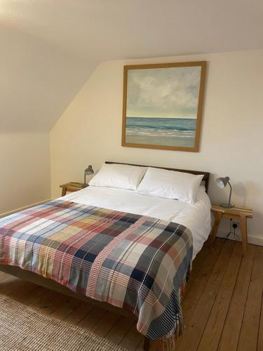 a bedroom with a bed with a painting on the wall at Harbourside Apartment in Eyemouth