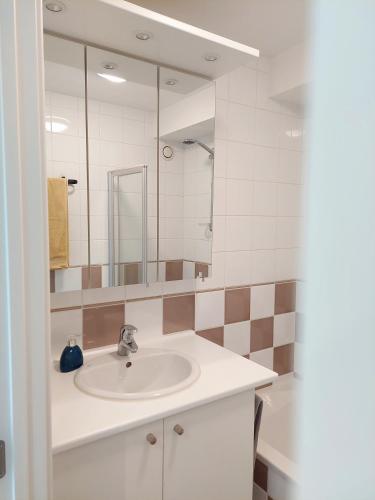 ein Badezimmer mit Waschbecken und großem Spiegel in der Unterkunft Studio 3 Bredene met strandcabine in Bredene