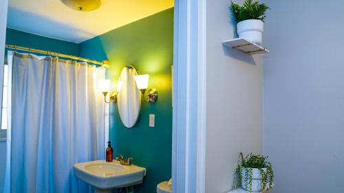 a bathroom with green walls and a sink and a mirror at Franklin Park condo 5 mins from airport, Walk to Conservatory in Columbus