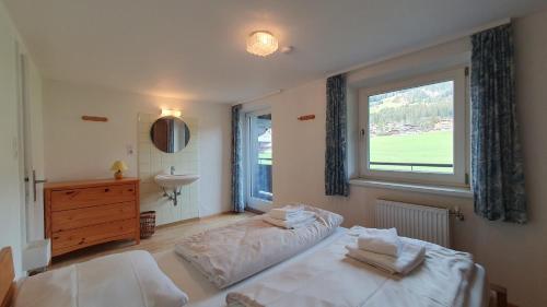 een slaapkamer met een bed, een wastafel en een raam bij Haus Therese in Kirchberg in Tirol