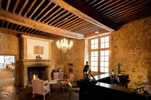 a living room with a fireplace and a chandelier at Château de Fontanges in Onet le Château