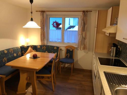 eine kleine Küche mit einem Tisch und einem Esszimmer in der Unterkunft Haus Konzett in Klösterle am Arlberg