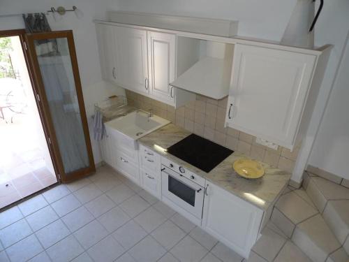 una cucina con mobili bianchi e un lavandino di Lou Marcelou - Apartment Two a Sainte-Croix-de-Verdon