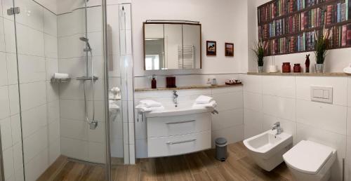 uma casa de banho com um chuveiro, um lavatório e um WC. em Port Marina "Schlagseite" em Bremerhaven