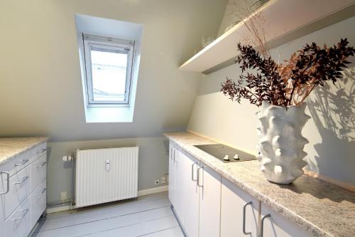 a kitchen with a vase of flowers on a counter at Perfect Apartment for Friends & Families in central Copenhagen in Copenhagen