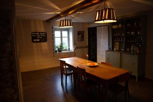 a dining room with a wooden table and chairs at Un petit bout du monde in Saint-Georges-en-Couzan