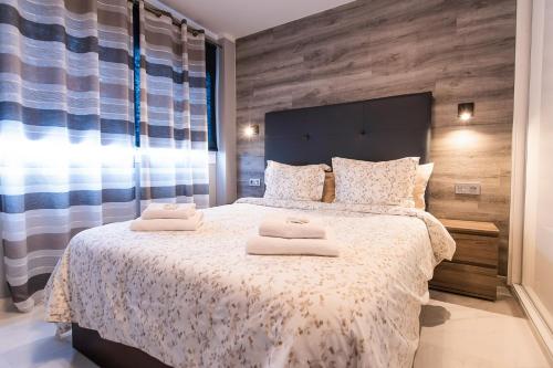 Luxury 2 bedroom apartment in Los Cristianos في لوس كريستيانوس: غرفة نوم بسرير كبير عليها منشفتين