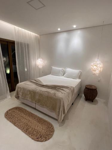 ein weißes Schlafzimmer mit einem großen Bett und einem Teppich in der Unterkunft Ronco do Mar Jeri in Jericoacoara