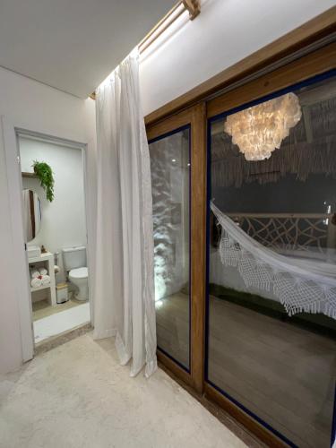 a bathroom with a sliding glass door with a chandelier at Ronco do Mar Jeri in Jericoacoara