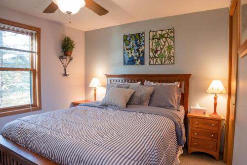 ein Schlafzimmer mit einem Bett, zwei Lampen und einem Fenster in der Unterkunft TheLake House in Tomahawk