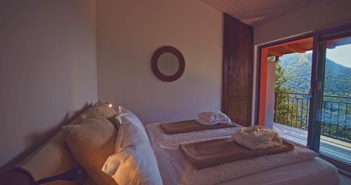 a bedroom with a bed and a window with a view at Osteria Manciana con Alloggio MONTE GENEROSO in Scudellate