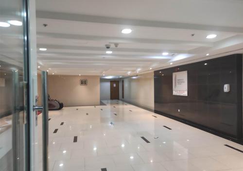 a hallway with a large white tile floor in a building at Private Room In shared apartment in heart of Ajman in Ajman 