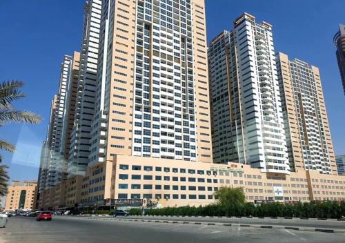 a large building with tall skyscrapers in a city at Private Room In shared apartment in heart of Ajman in Ajman 