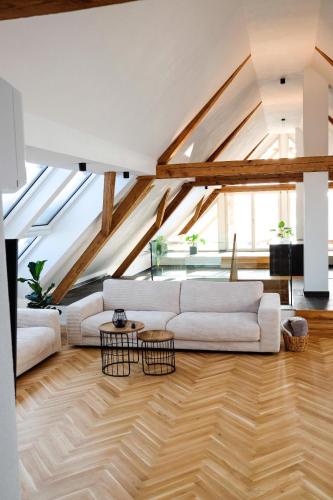 a living room with a white couch and wooden floors at Trautesheim Ferienwohnungen in Wangen im Allgäu