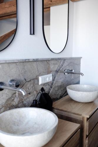 a bathroom with two sinks and a mirror at Trautesheim Ferienwohnungen in Wangen im Allgäu