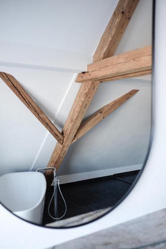 a mirror in a room with a chair and a ceiling at Trautesheim Ferienwohnungen in Wangen im Allgäu