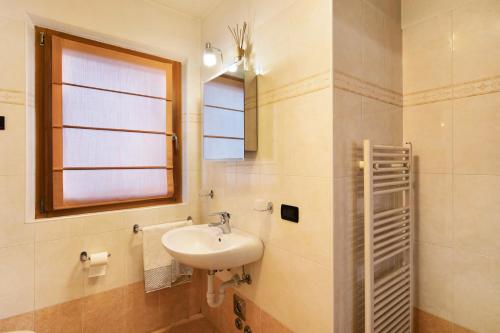ein Bad mit einem Waschbecken und einem Fenster in der Unterkunft Red Casa Maurizio in Livigno