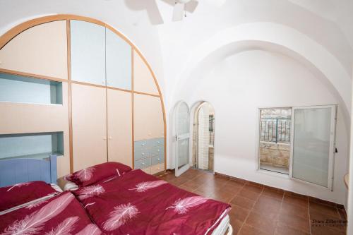 a bedroom with a bed and some windows at Temple mount view in Yerushalayim