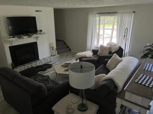 a living room with two couches and a fireplace at Breezeway Bay - Waterfront Full House in Wisconsin Dells