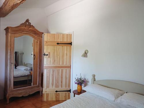 - une chambre avec un grand miroir et un lit dans l'établissement Gite Amandier, Ferme Bel Air, Riez, à Riez