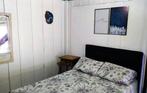 a small bedroom with a bed and a table at Oka do Mar - Hospedaria de Quartos e Casa na Ilha do Mel - Nova Brasília in Ilha do Mel