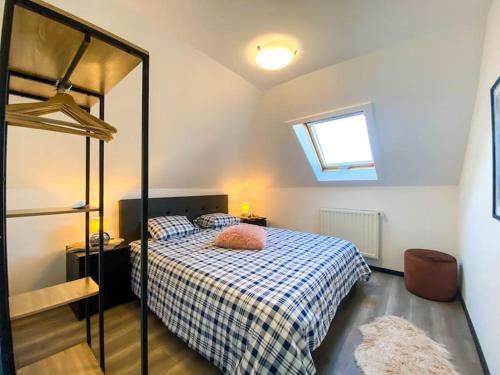 a bedroom with a bed with a blue and white checkered blanket at Loft Monaco - Ruime vakantieloft in De Panne