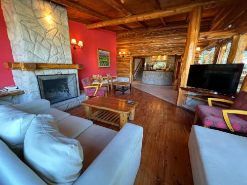 sala de estar con sofá y chimenea en Hostería y Cabañas Quime Quipan by Nordic en San Carlos de Bariloche