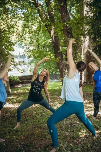 a group of women doing yoga in a park at Les Suites de l'Ile Barbe in Lyon