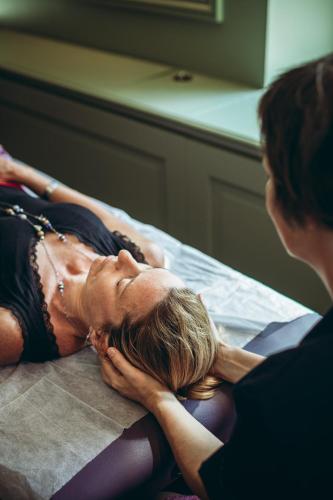 a woman laying on a bed talking to a woman at Les Suites de l'Ile Barbe in Lyon