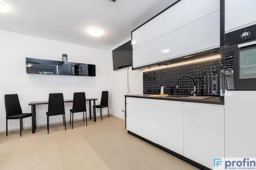 uma cozinha com cadeiras pretas e um balcão com uma mesa em Apartamenty na Górce em Olsztyn